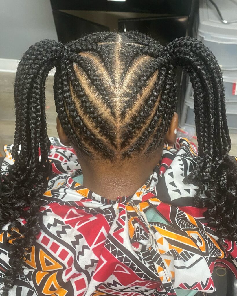 A person wearing braided ponytails with a chevron cornrow pattern and curled braid ends.