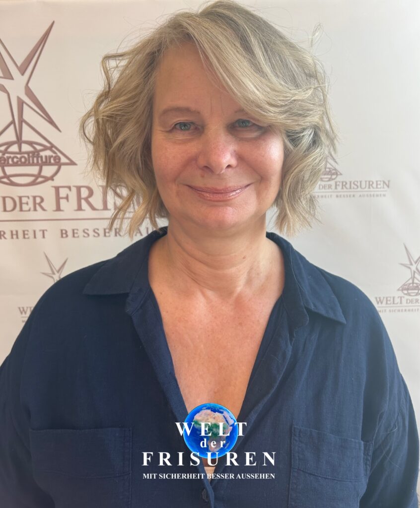 A woman with a chin length messy bob in sandy ash blonde with soft tousled waves and natural volume.