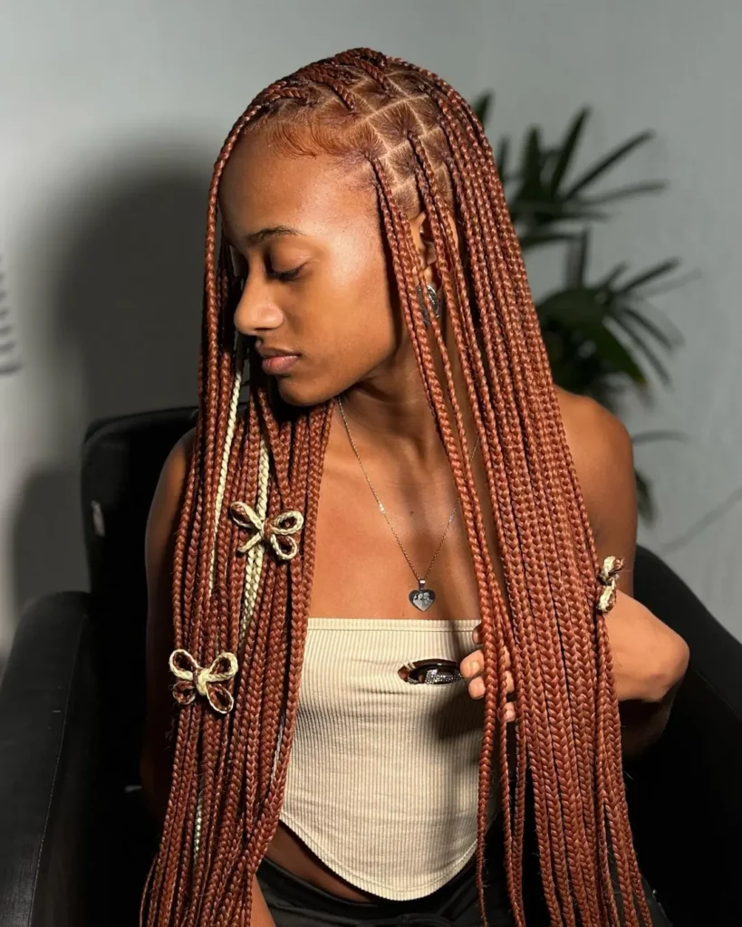 Copper blonde box braids with small decorative accessories and neat parts.