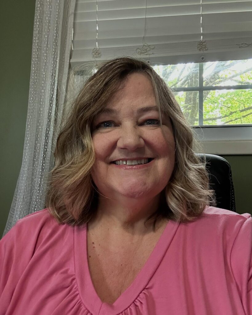 A woman with a shoulder-length textured lob featuring soft blonde highlights and gentle waves.