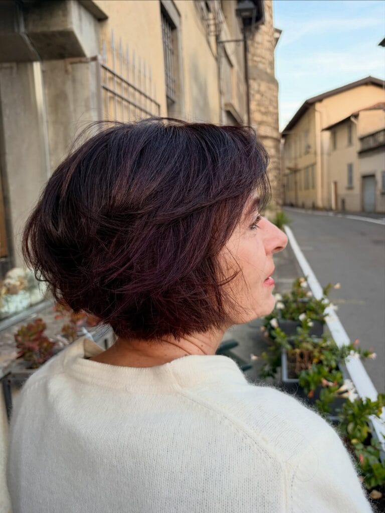 Short layered bob with soft texture and side-swept volume, colored in a rich deep mahogany shade that adds warmth and dimension.