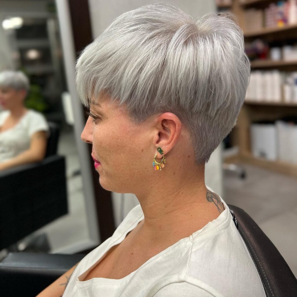 Very short silver pixie cut with closely tapered sides and back and a longer, softly textured top.
