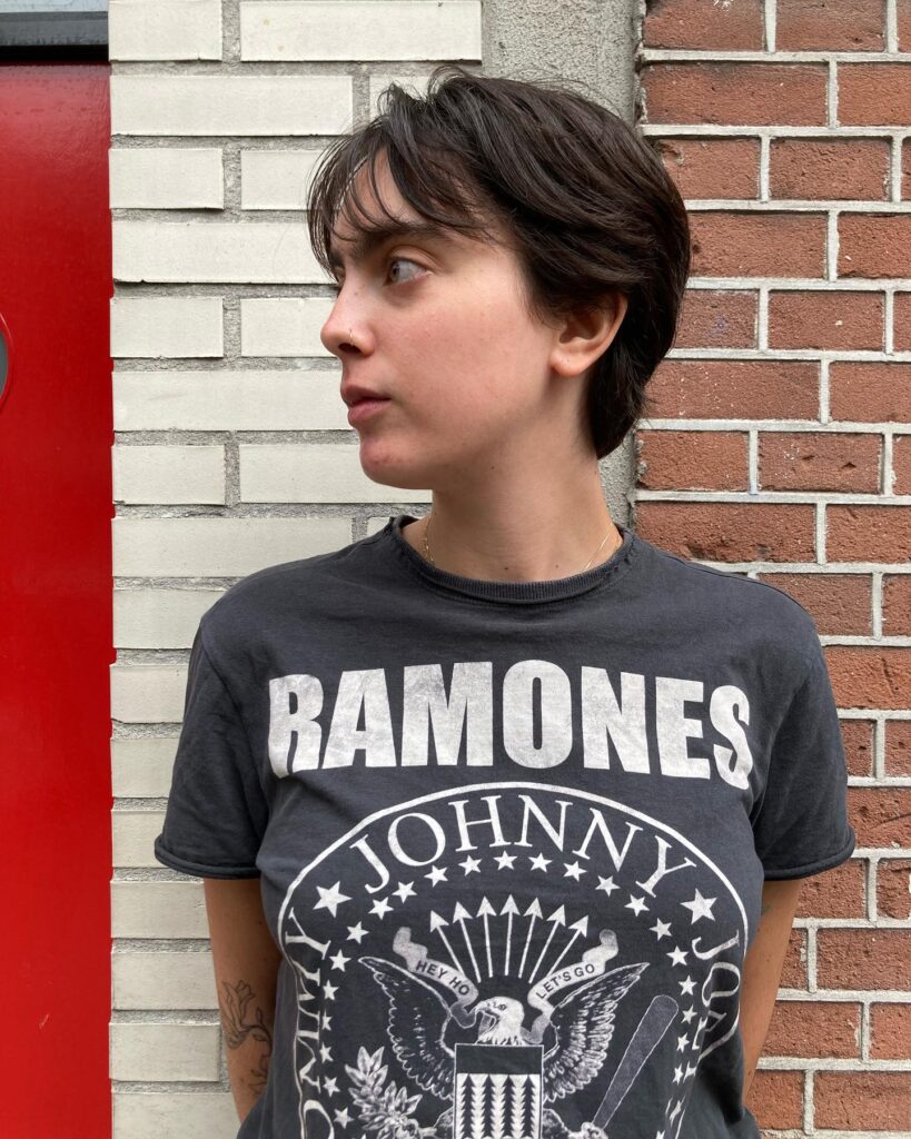 A short layered tomboy crop with soft natural layers, light fringe, and deep brown hair.