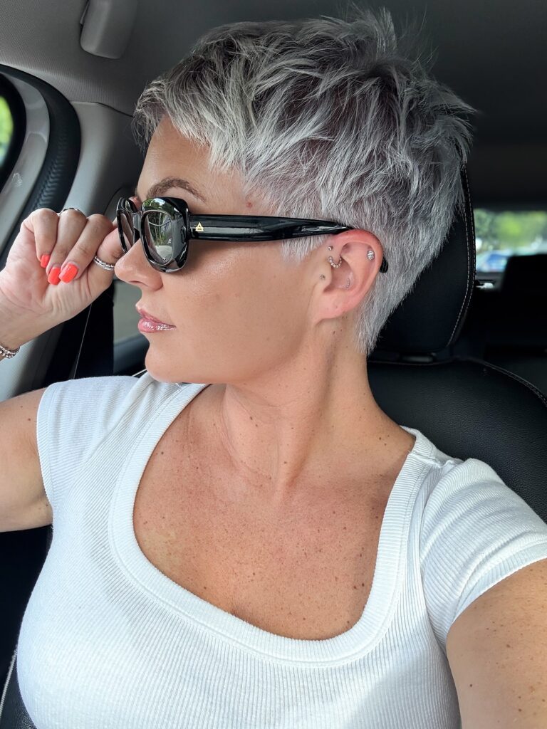 A woman with a choppy silver and gray textured pixie cut with piecey layers on top.