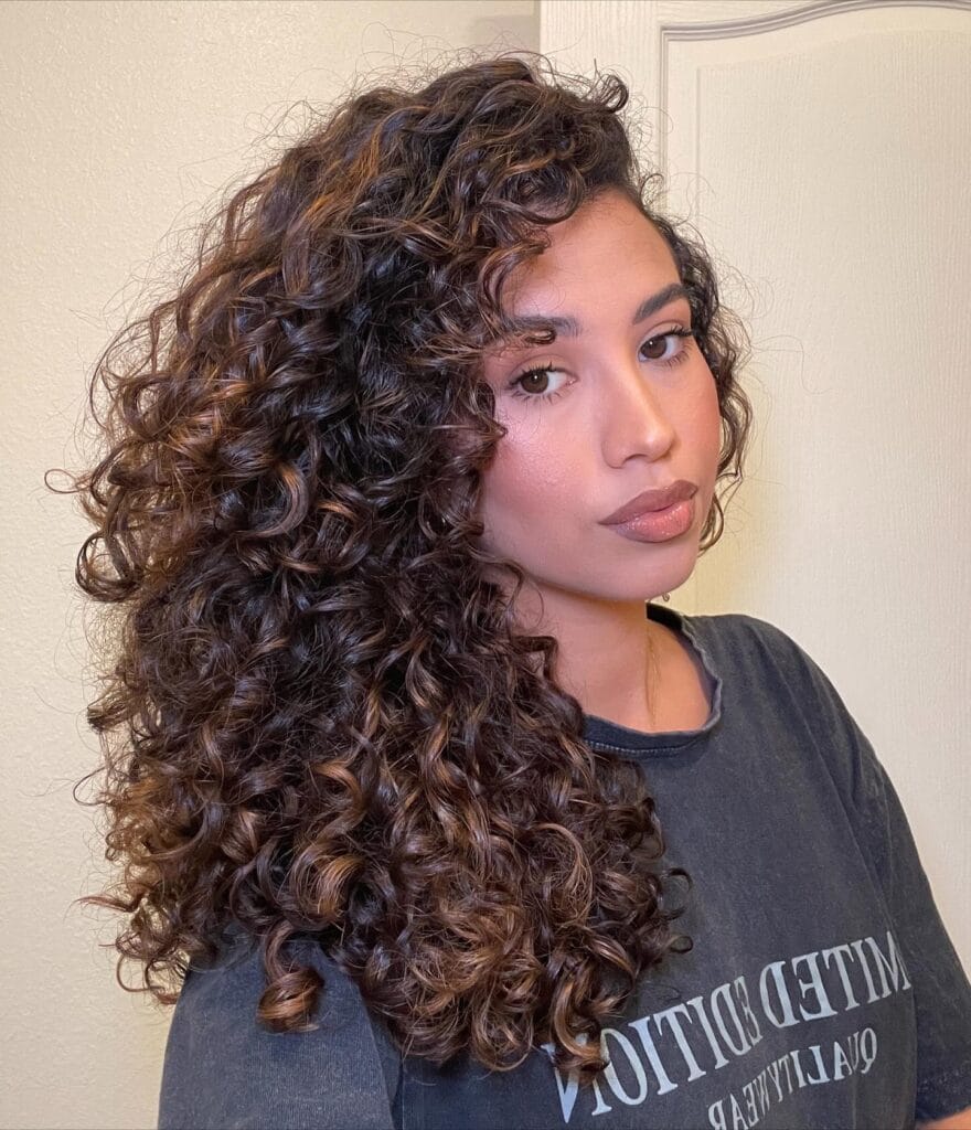 Long curly hairstyle with soft layers and natural volume throughout.