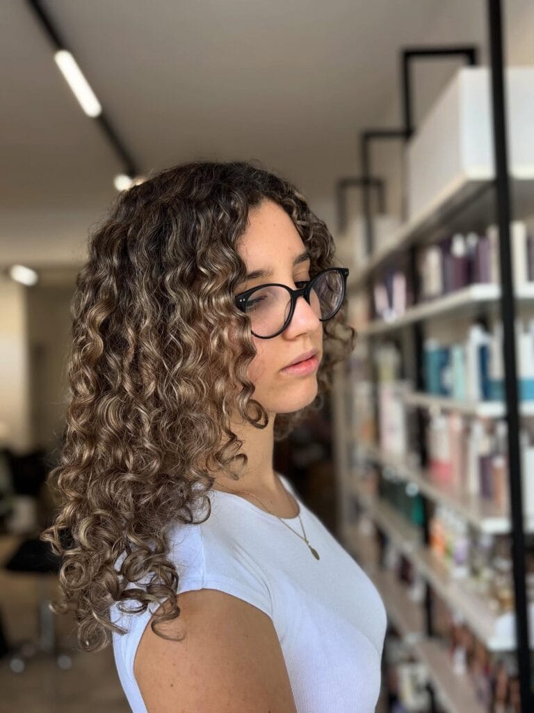 Long curly hairstyle with subtle layers and soft natural shine.