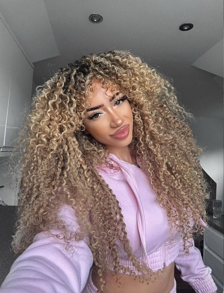 Extra long curly hairstyle with full texture and tight defined curls.