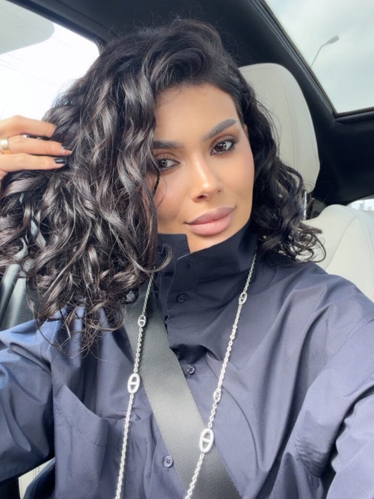 Shoulder length curly hairstyle with defined glossy curls and soft layers.