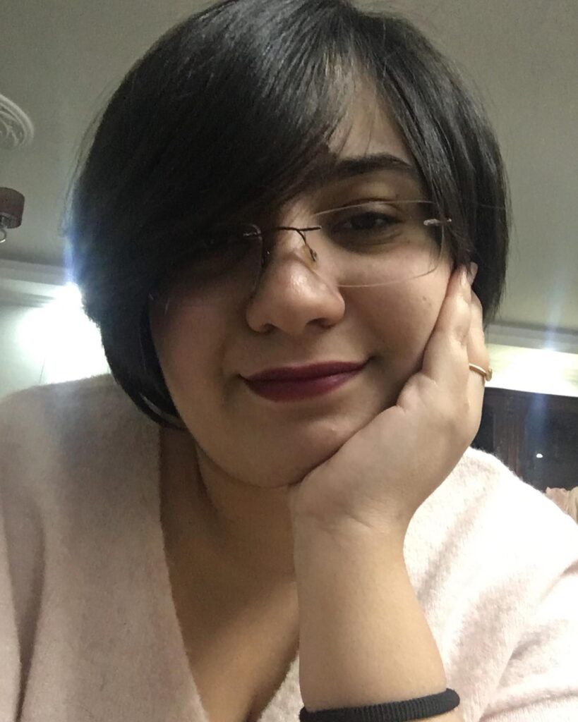 A woman with a dark brown chin-length bob styled with a side-swept fringe and a smooth finish.
