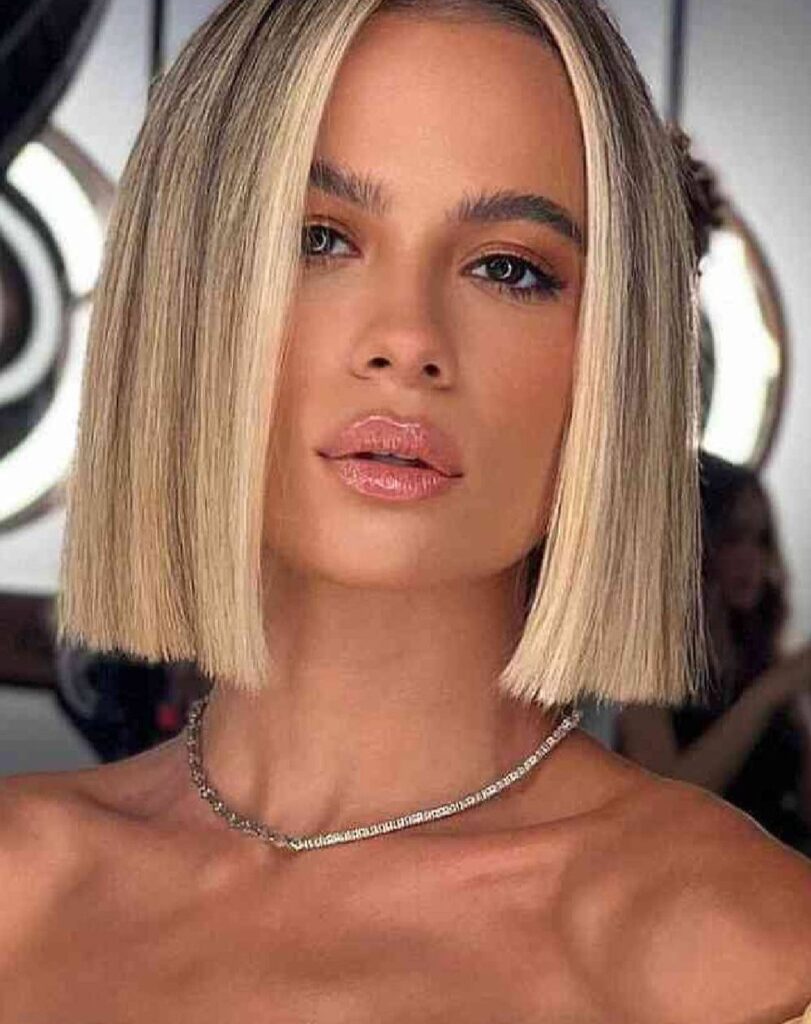 Chin length blunt bob with a center part and sleek blonde finish.