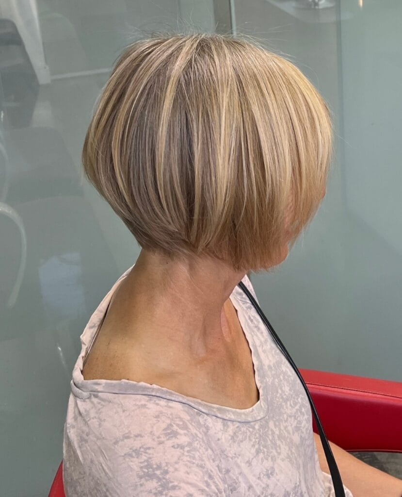 Stacked blonde bob with rounded volume and shorter layers at the back.