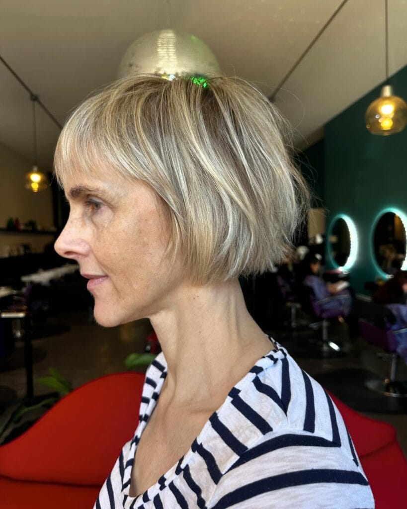 Chin length blonde bob with wispy layers and a soft, airy finish.