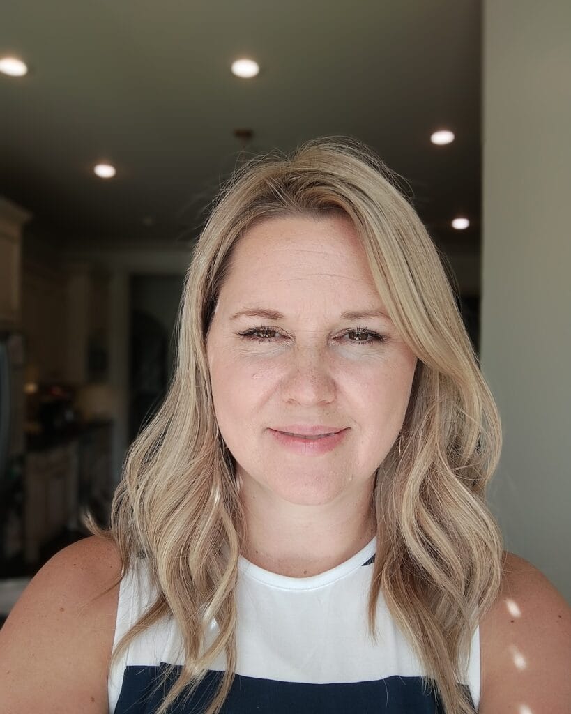 Medium length blonde hair with soft waves and light layers for natural movement.