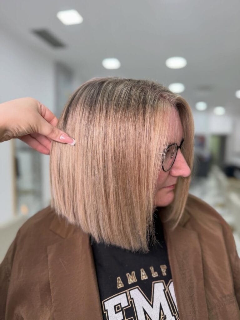 Shoulder length blonde blunt cut with a sleek and straight finish.