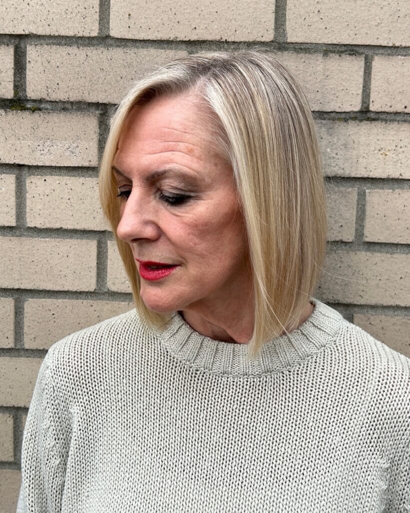 Chin length blonde bob with a side part and a smooth, sleek finish.