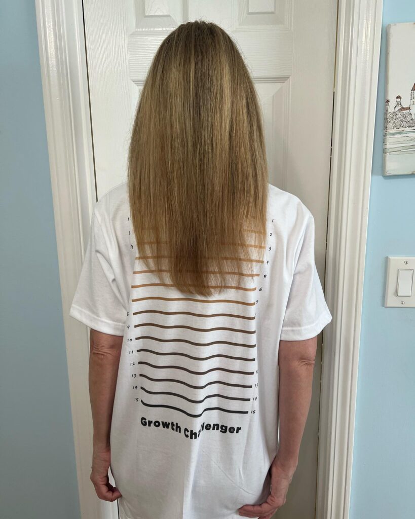 The back view of a woman with long straight sandy blonde hair styled in a soft U-shaped cut.