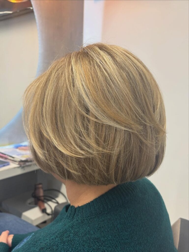 Layered blonde bob with volume at the crown and soft shaping.