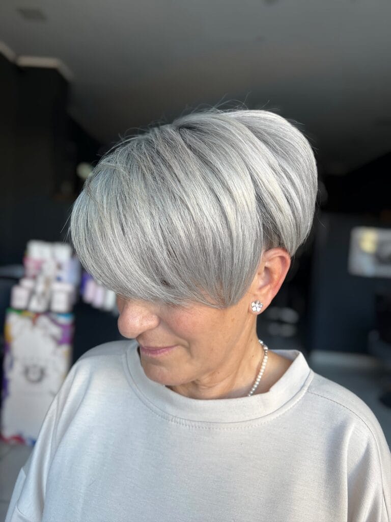 Short silver pixie bob with textured layers and longer front pieces.