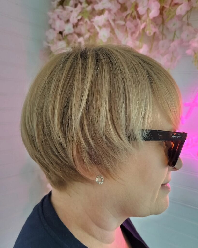 Short blonde bob with a deep side part and smooth polished finish.