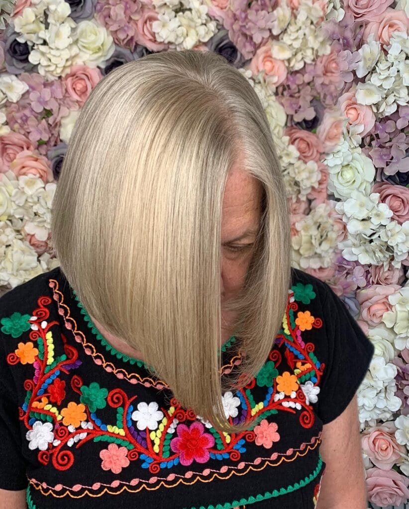 Straight long bob with blonde color and soft face framing shape.