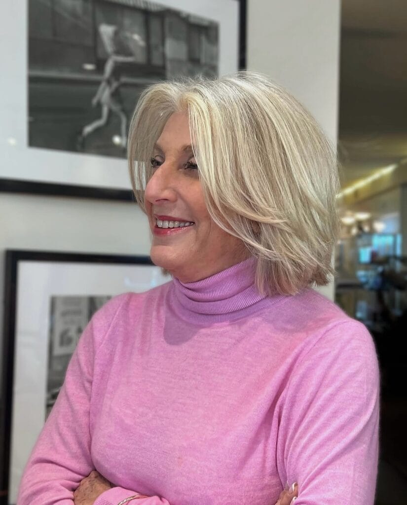 Chin length blonde bob with feathered layers and soft movement.