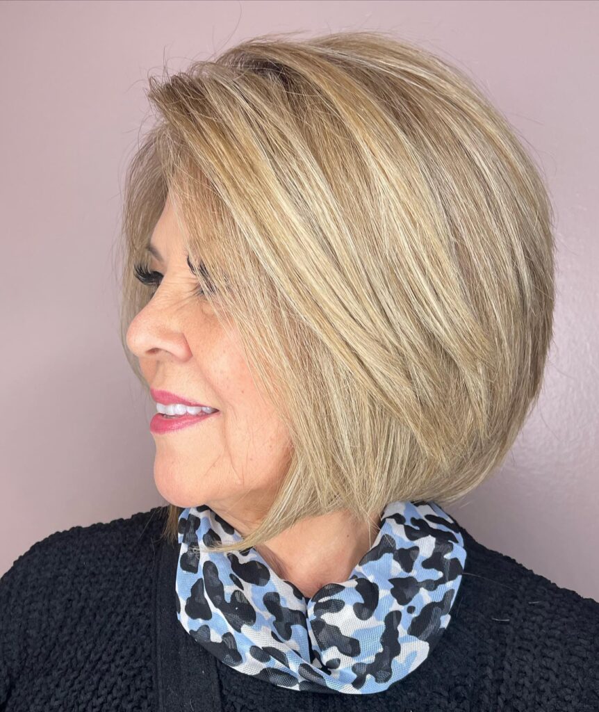 A woman in profile with a graduated sandy blonde bob featuring golden highlights and smooth layers.