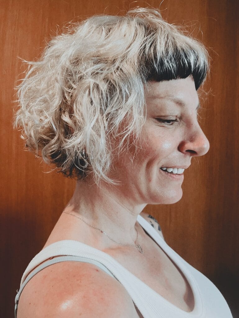 Short curly bob with choppy layers and micro fringe.