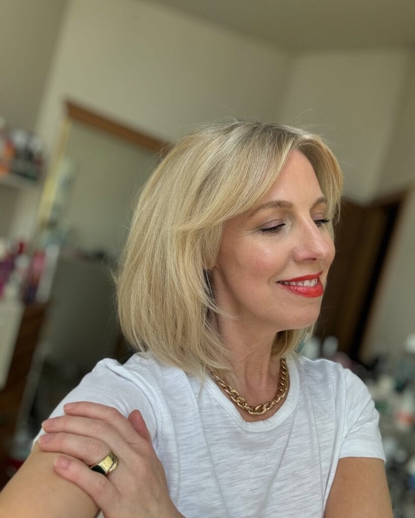 Shoulder length feathered bob with wispy fringe and soft blonde layers.