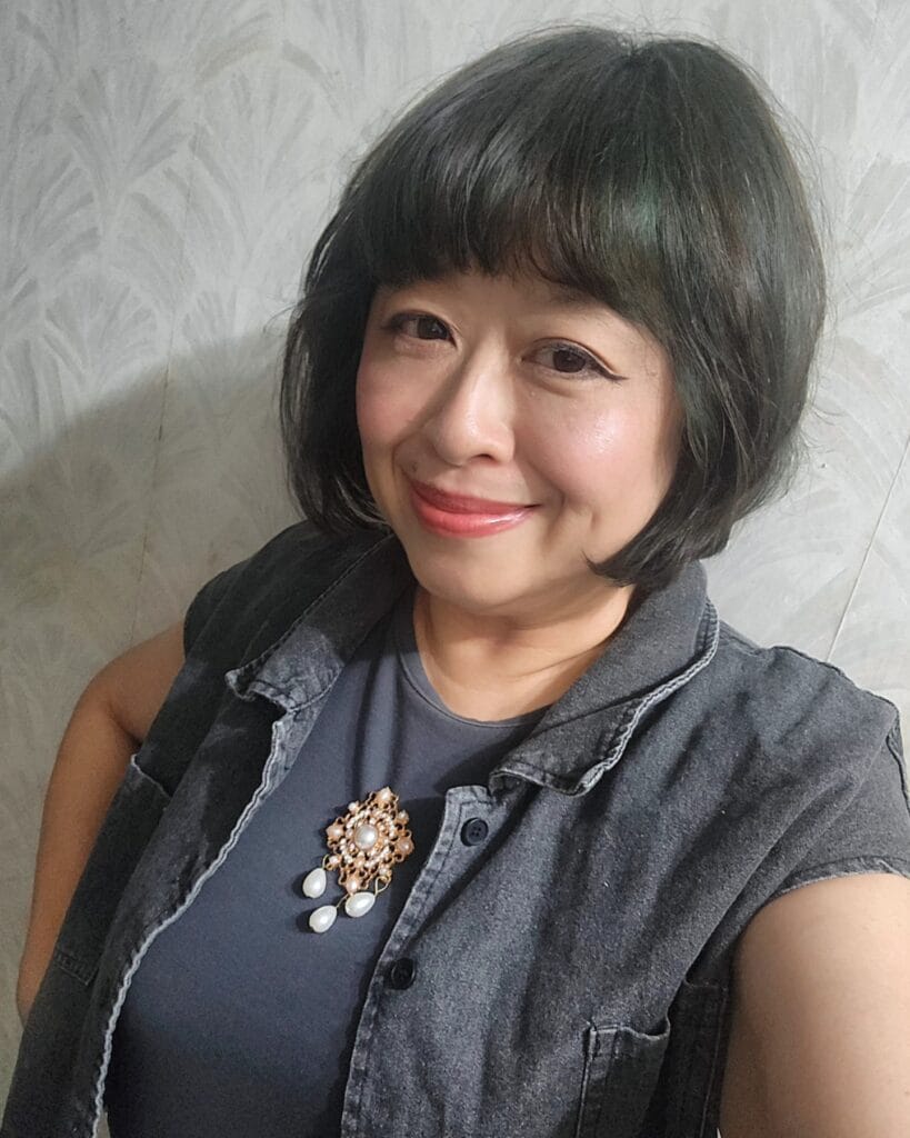 Chin length bob with full rounded fringe and smooth dark hair.