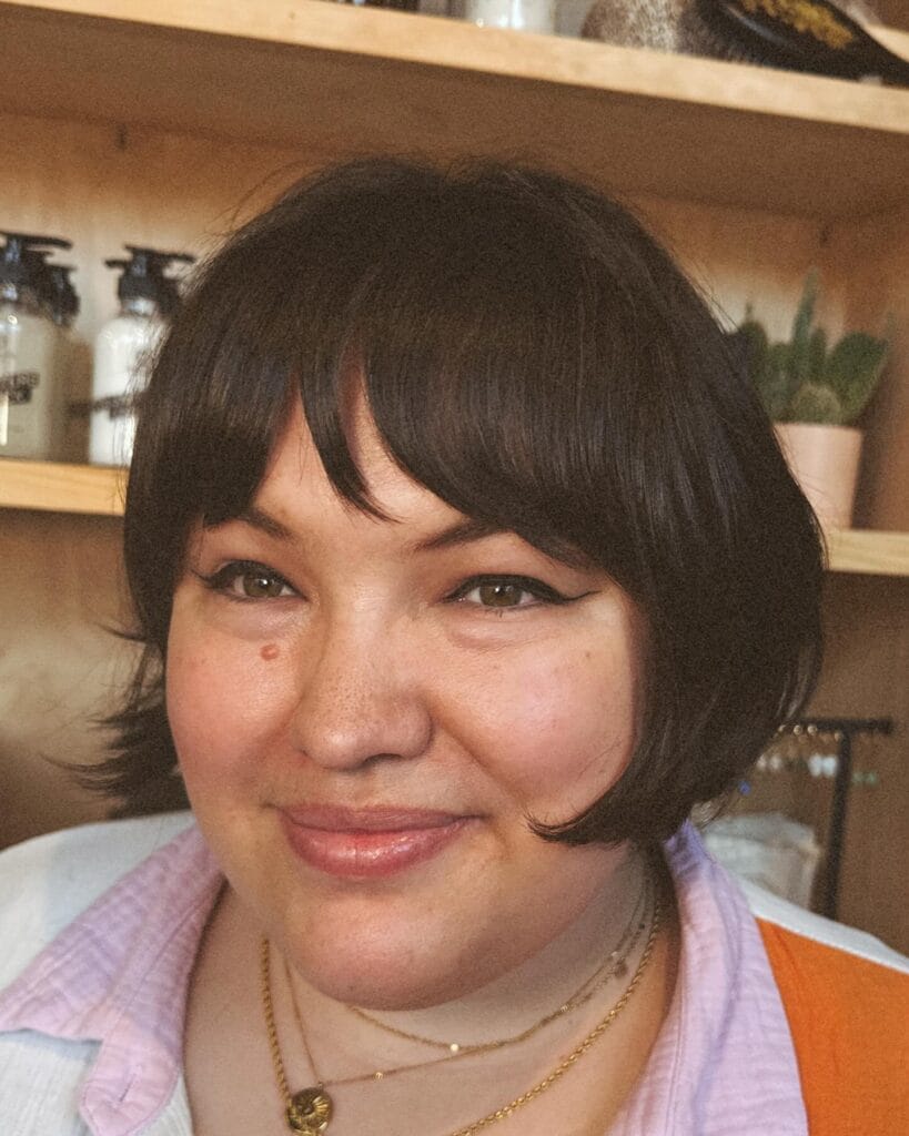 Rounded bob with soft layers and full fringe framing the face.