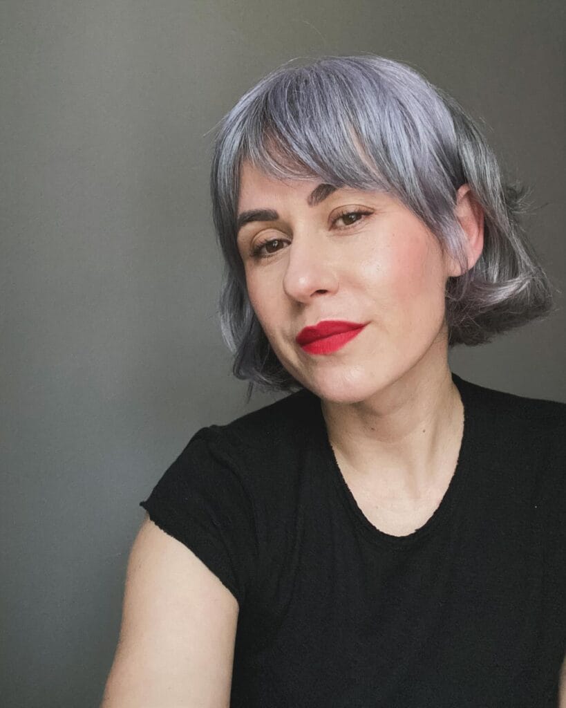 Short sleek silver bob with micro fringe and clean lines.