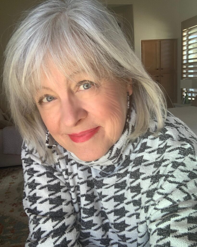 Chin length gray bob with wispy curtain bangs and soft inward curved ends.
