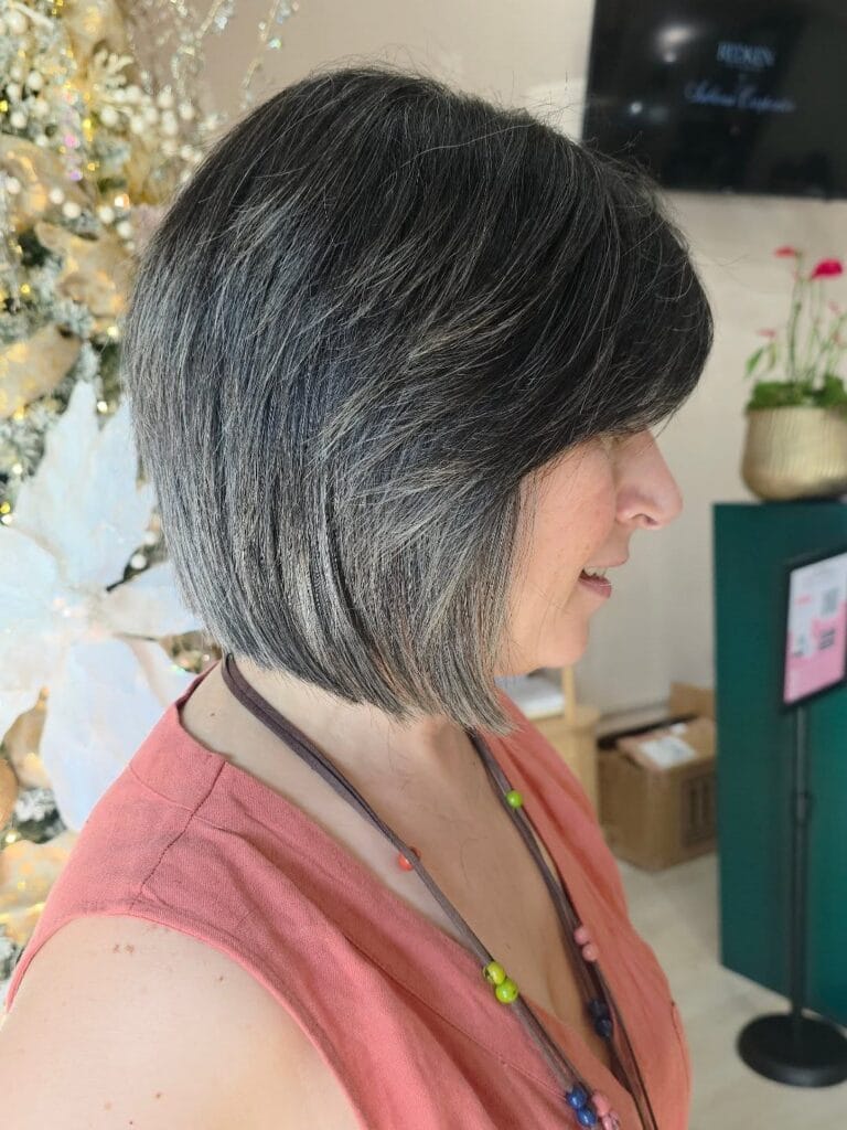 Layered gray bob with side swept bangs and soft movement.