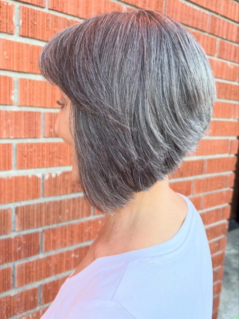 Angled gray bob with side bangs and a sleek tapered back.