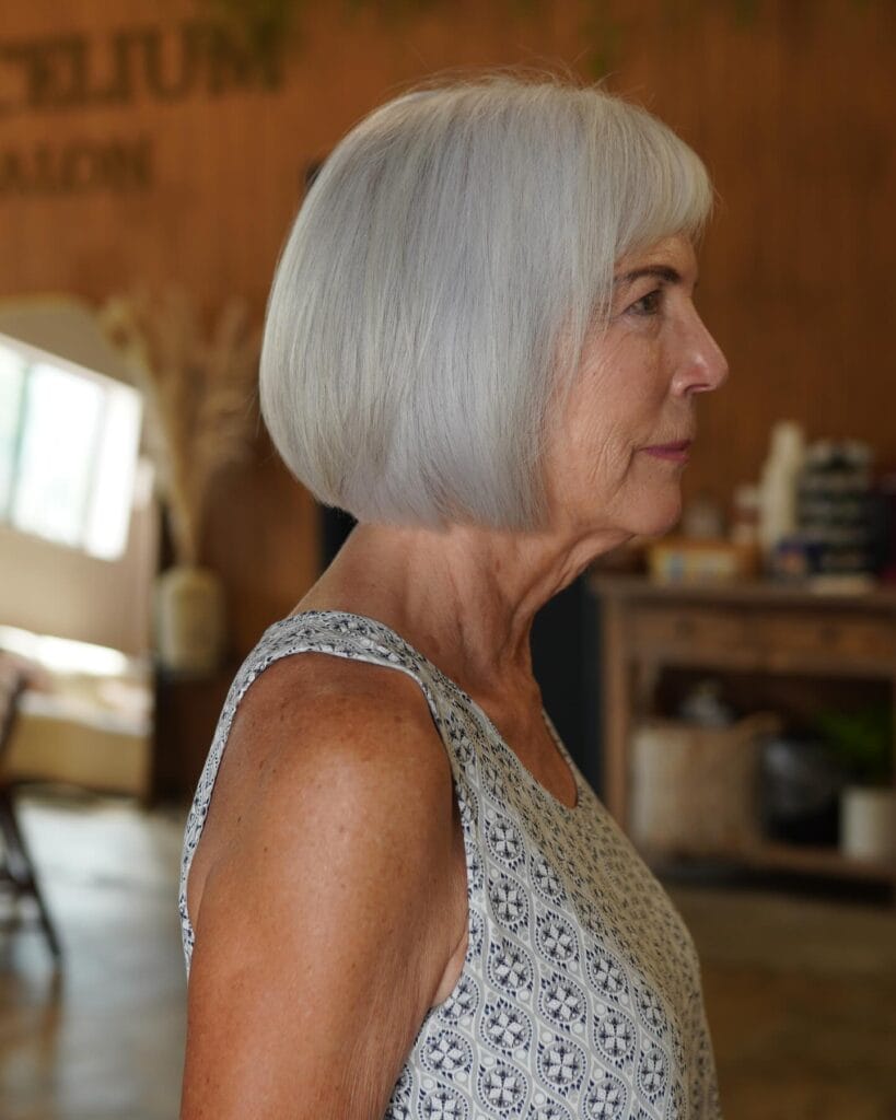 Chin length gray bob with blunt bangs and a smooth straight finish.