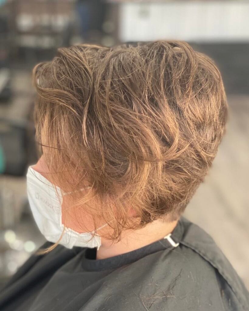 Short tousled inverted bob with soft layers and warm brown tones.