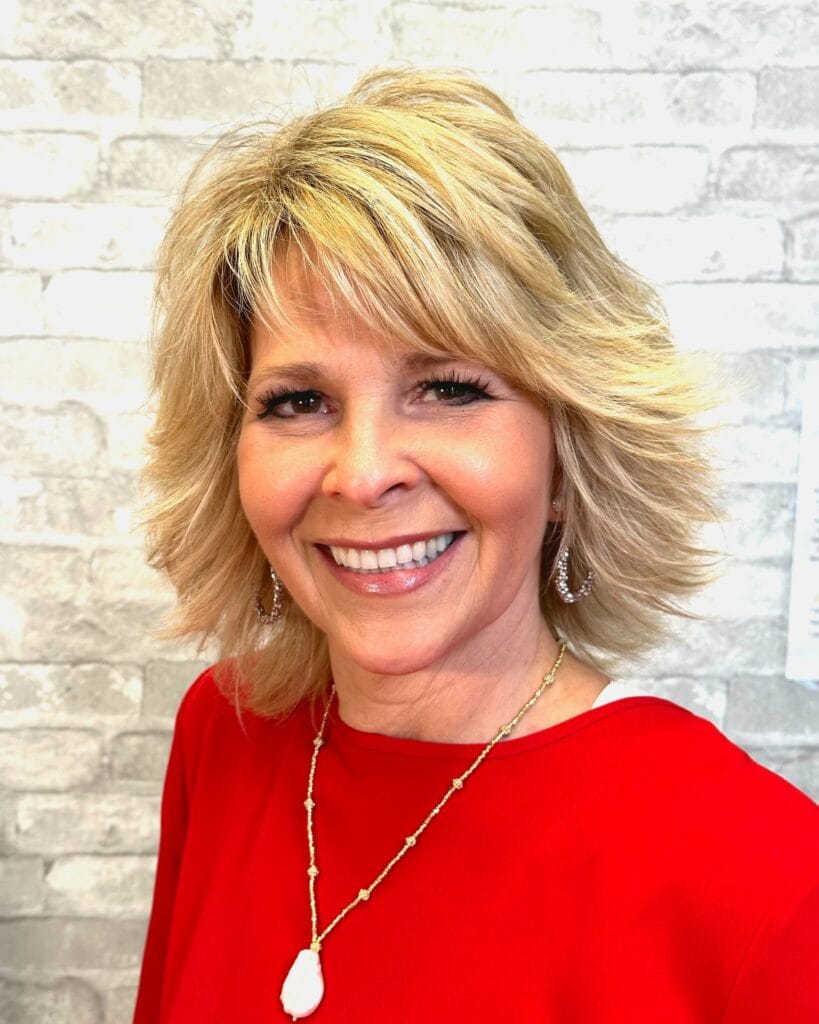 Blonde layered bob with feathered ends and voluminous shape.