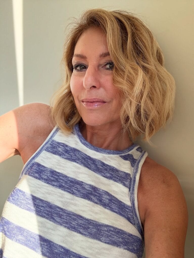 Chin length blonde layered bob with soft waves and natural texture.