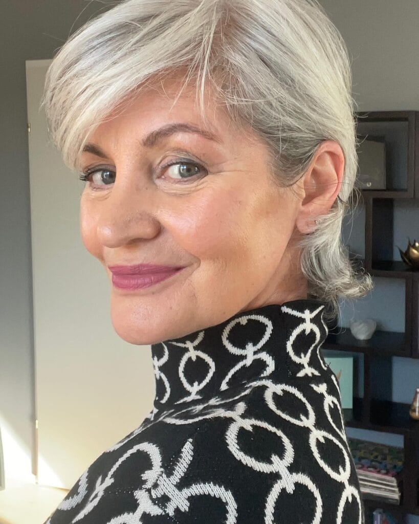 Short silver layered pixie bob with a soft side swept fringe.