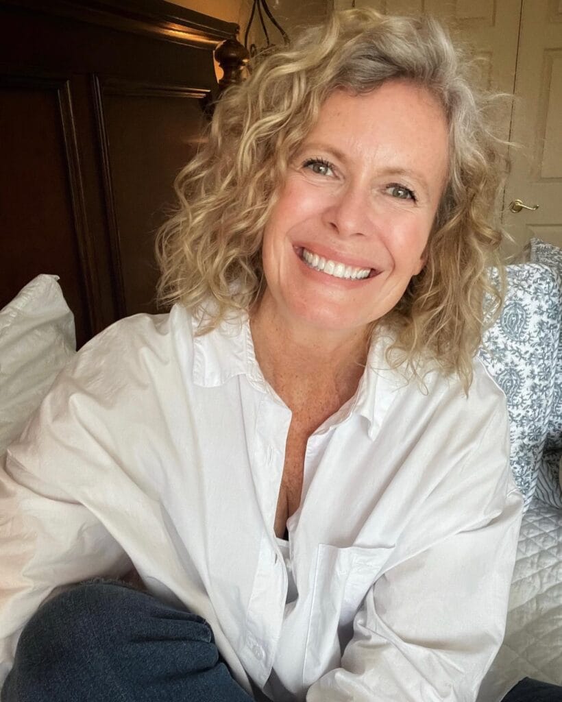 A curly messy bob with soft volume and warm blonde tones.