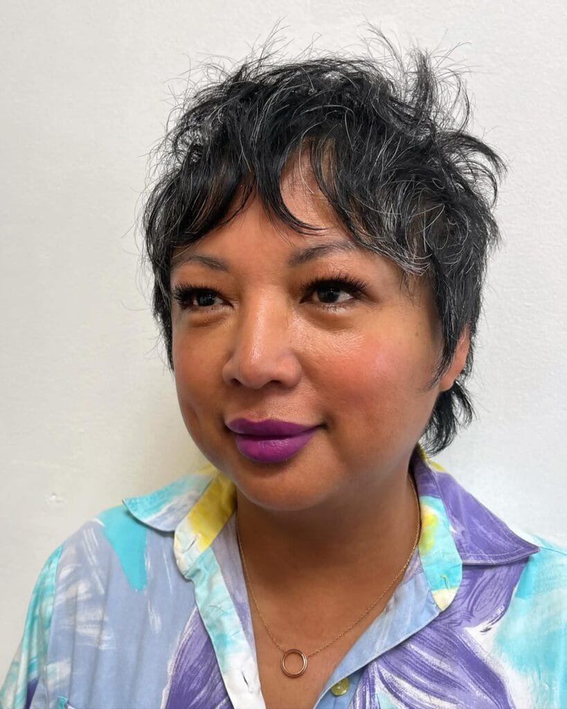 A short choppy pixie bob with textured layers and dark voluminous styling.