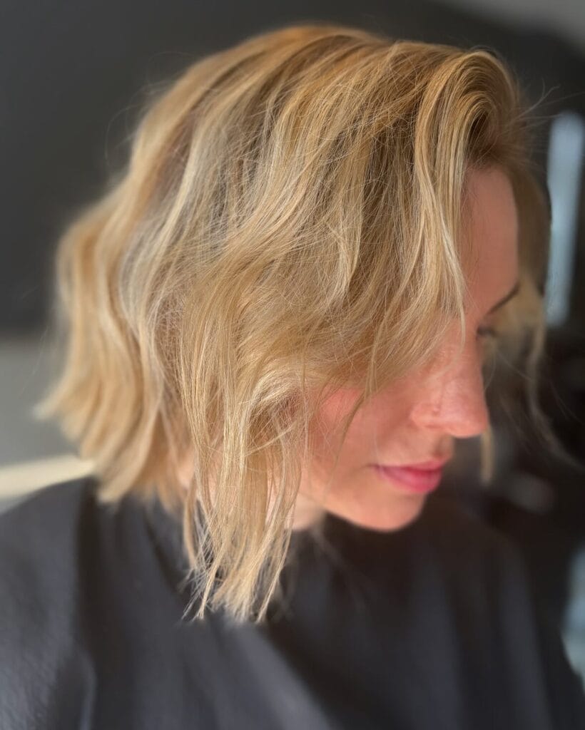A beachy blonde messy bob with tousled waves and soft layered texture.