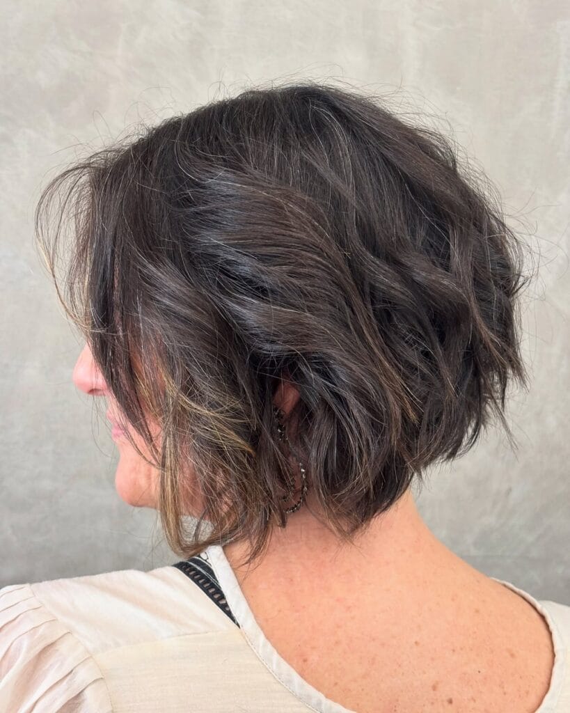 A voluminous textured messy bob with a tapered back and soft brunette waves.