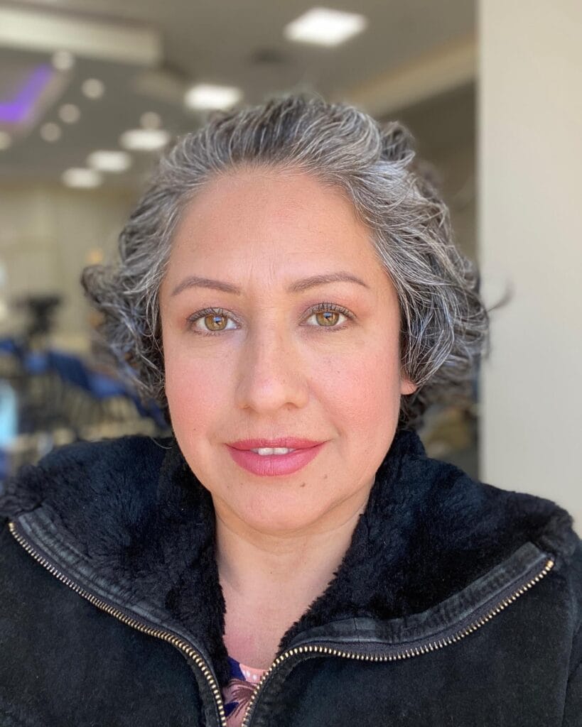 A short salt and pepper messy bob with soft waves and natural textured volume.