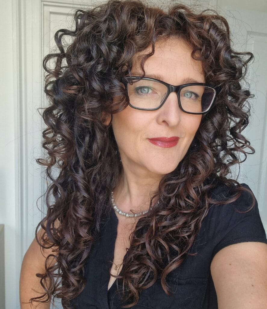 Long dark curly hair with defined spirals and layered shape.
