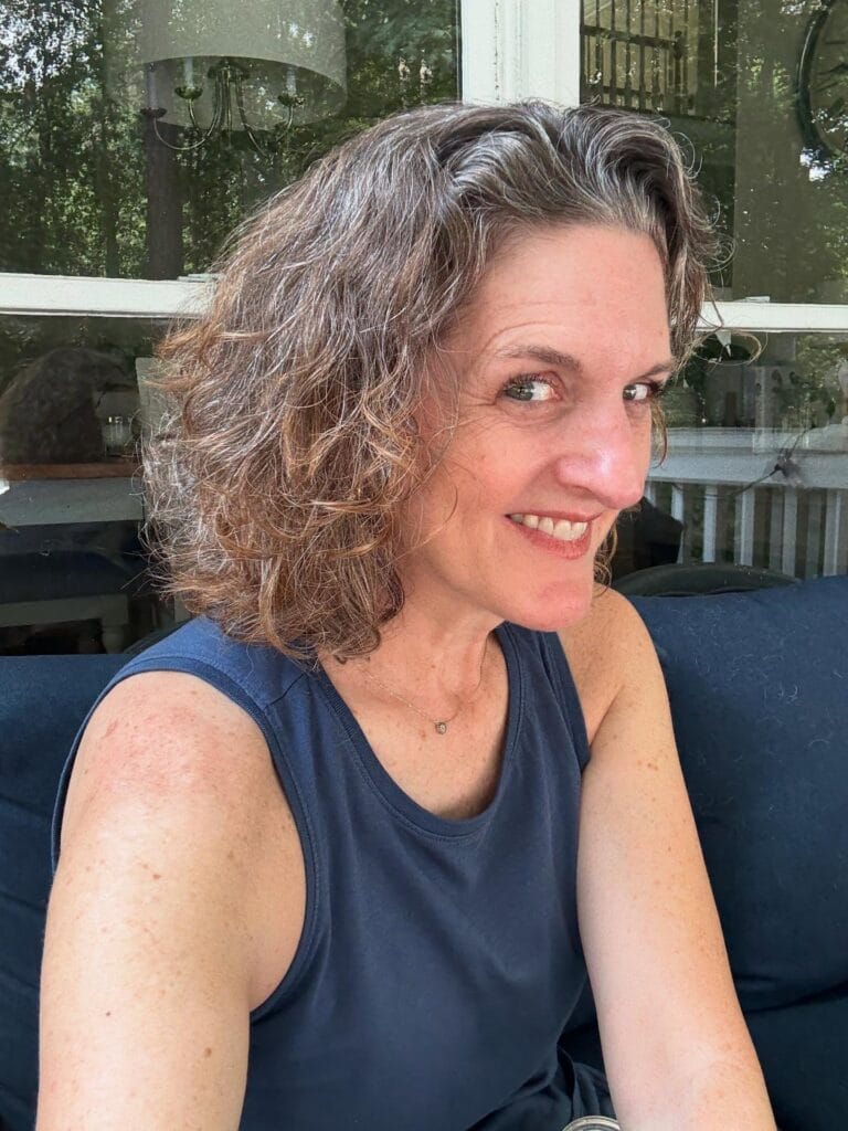 Short layered curly bob with natural salt and pepper texture and soft volume.