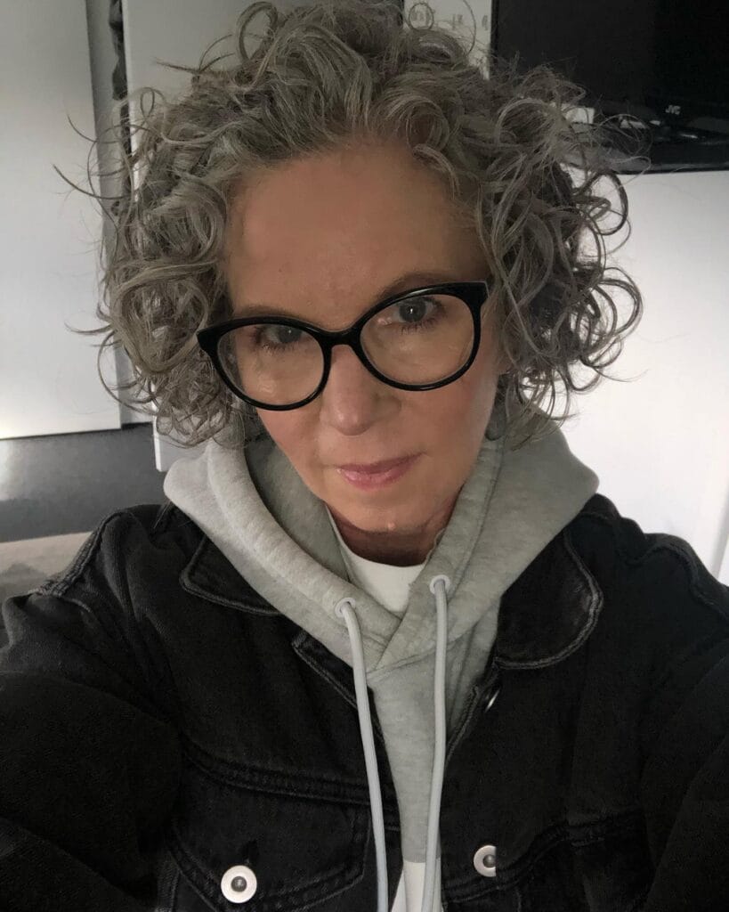 Short gray curly crop with soft natural texture.