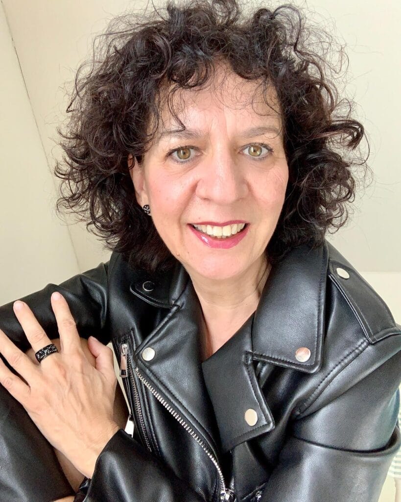 Short dark curly pixie with tight curls and volume.