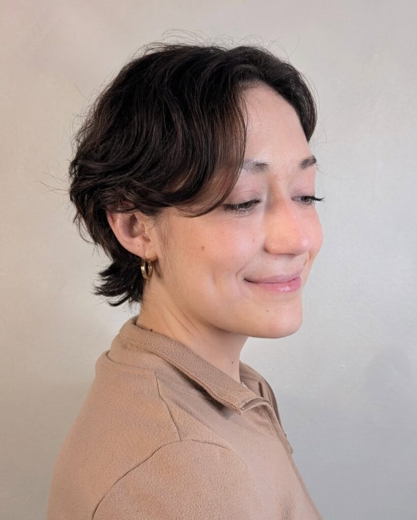 Brunette shaggy bob haircut with curtain layers and soft textured shape.