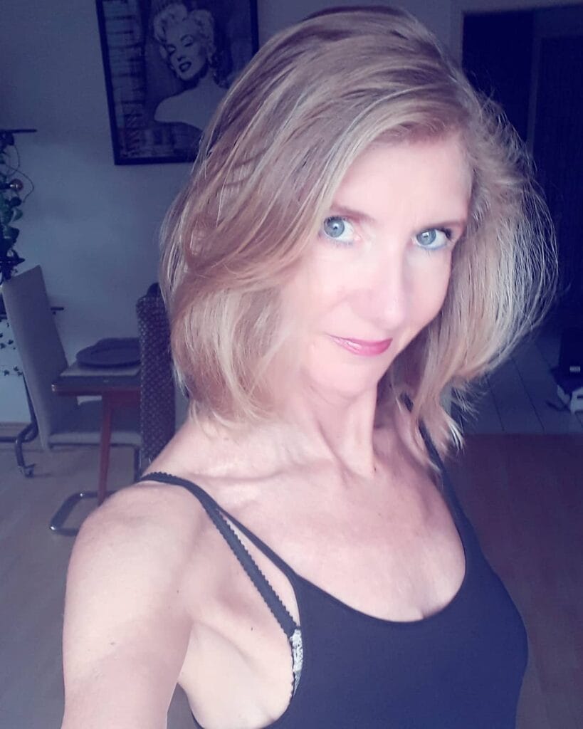 Wavy blonde shaggy bob haircut with layered texture and soft volume.